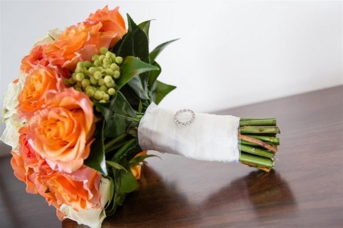 Букет украшенный белой атласной лентой и брошью